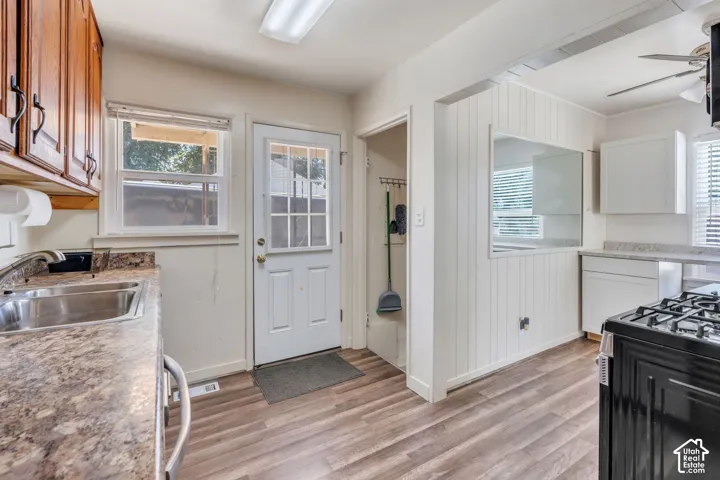 Kitchen featuring wood-finish flooring, wood cabinetry, laminate countertops, and a white paneled door with glass inserts