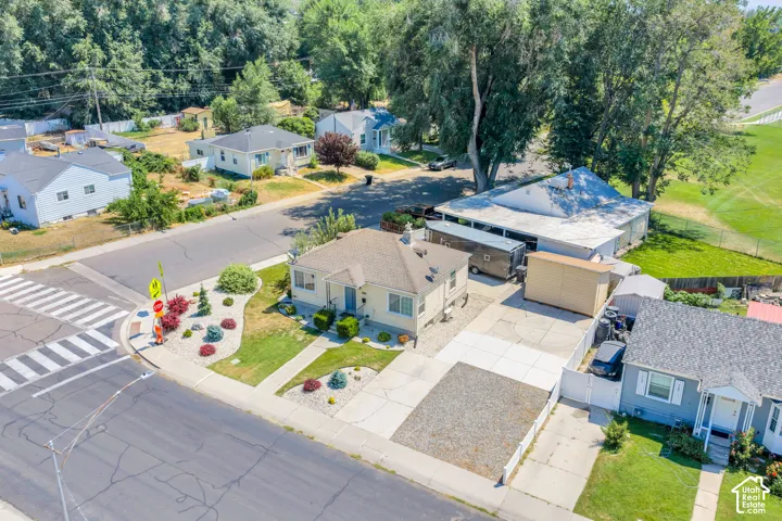 Single-story residence featuring a front yard with mature landscaping and a paved driveway