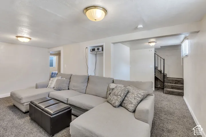 Finished room featuring plush carpet flooring, recessed ceiling lighting, and a built-in projector shelf