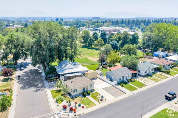 Aerial view showcasing a residential street with diverse home styles, mature trees, and landscaping