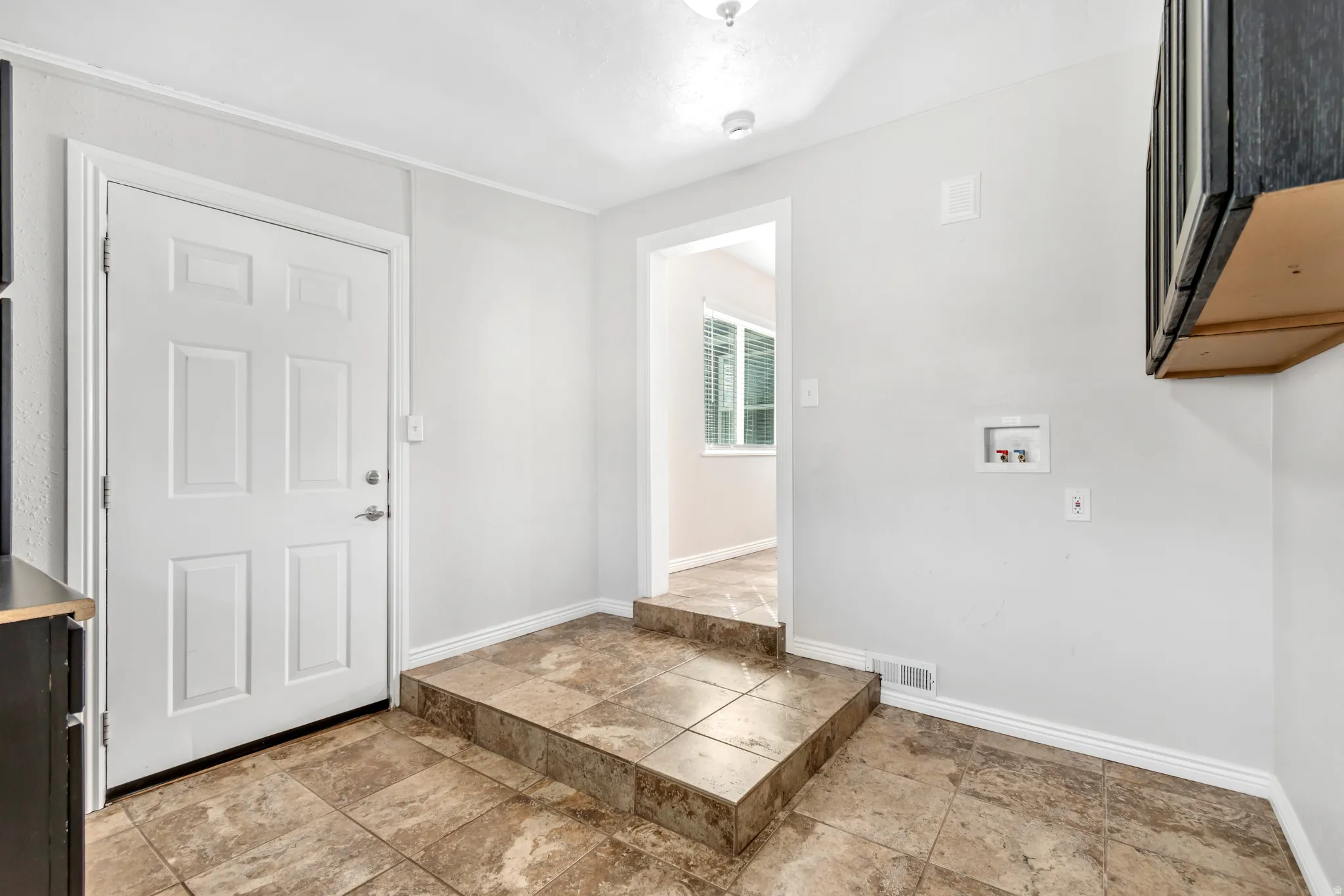 Entrance foyer featuring baseboards and light stone finish flooring