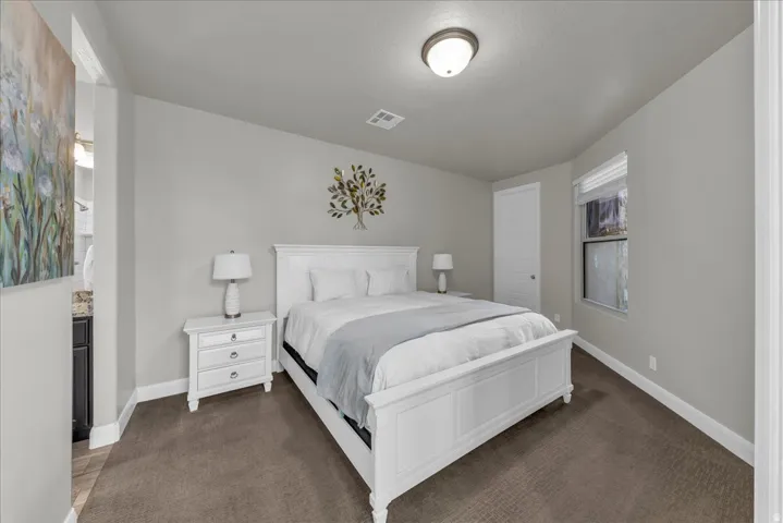 Bedroom with baseboards and dark colored carpet