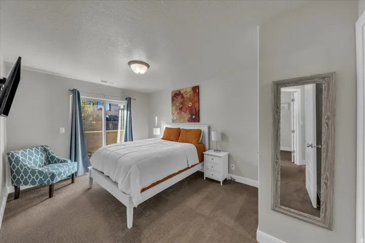 Carpeted bedroom featuring a textured ceiling and access to outside