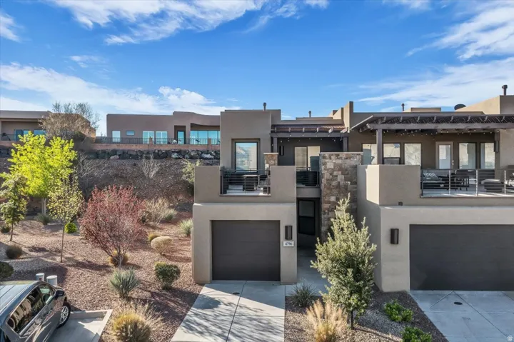 View of front of home featuring stucco siding, a garage, and driveway