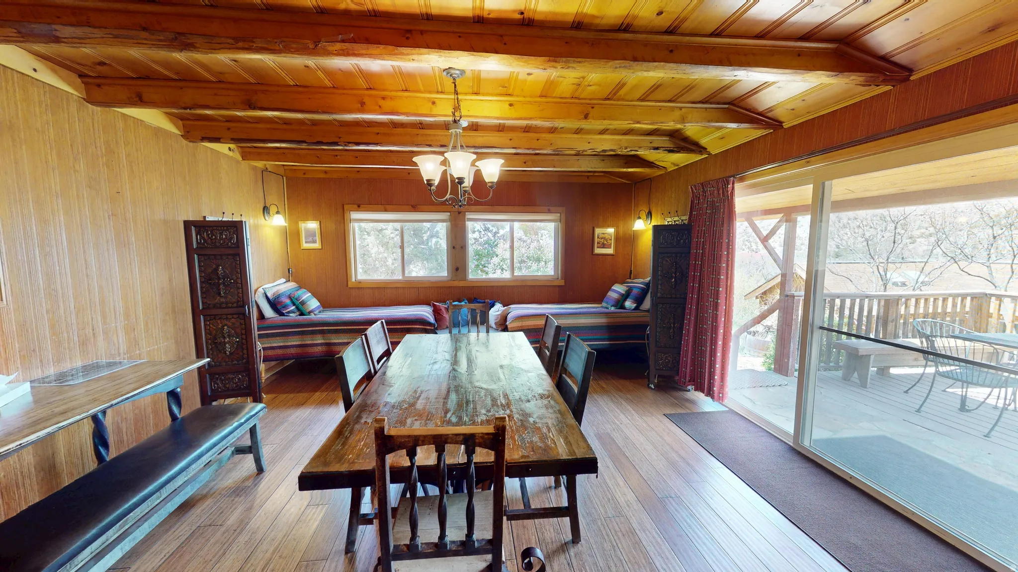 Dining space featuring a chandelier, hardwood / wood-style flooring, wooden walls, and a wood ceiling with exposed beams