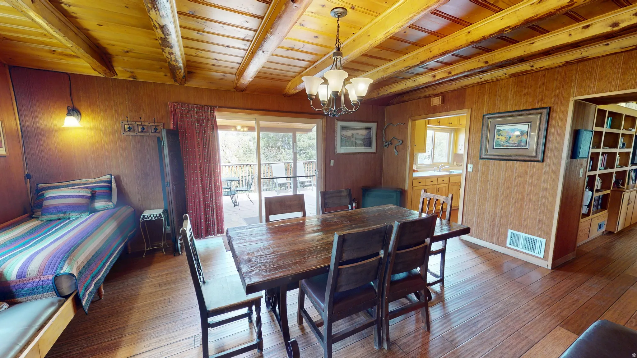 Dining area featuring wooden walls, hanging lights, hardwood / wood-style floors, and a wood ceiling with exposed beams