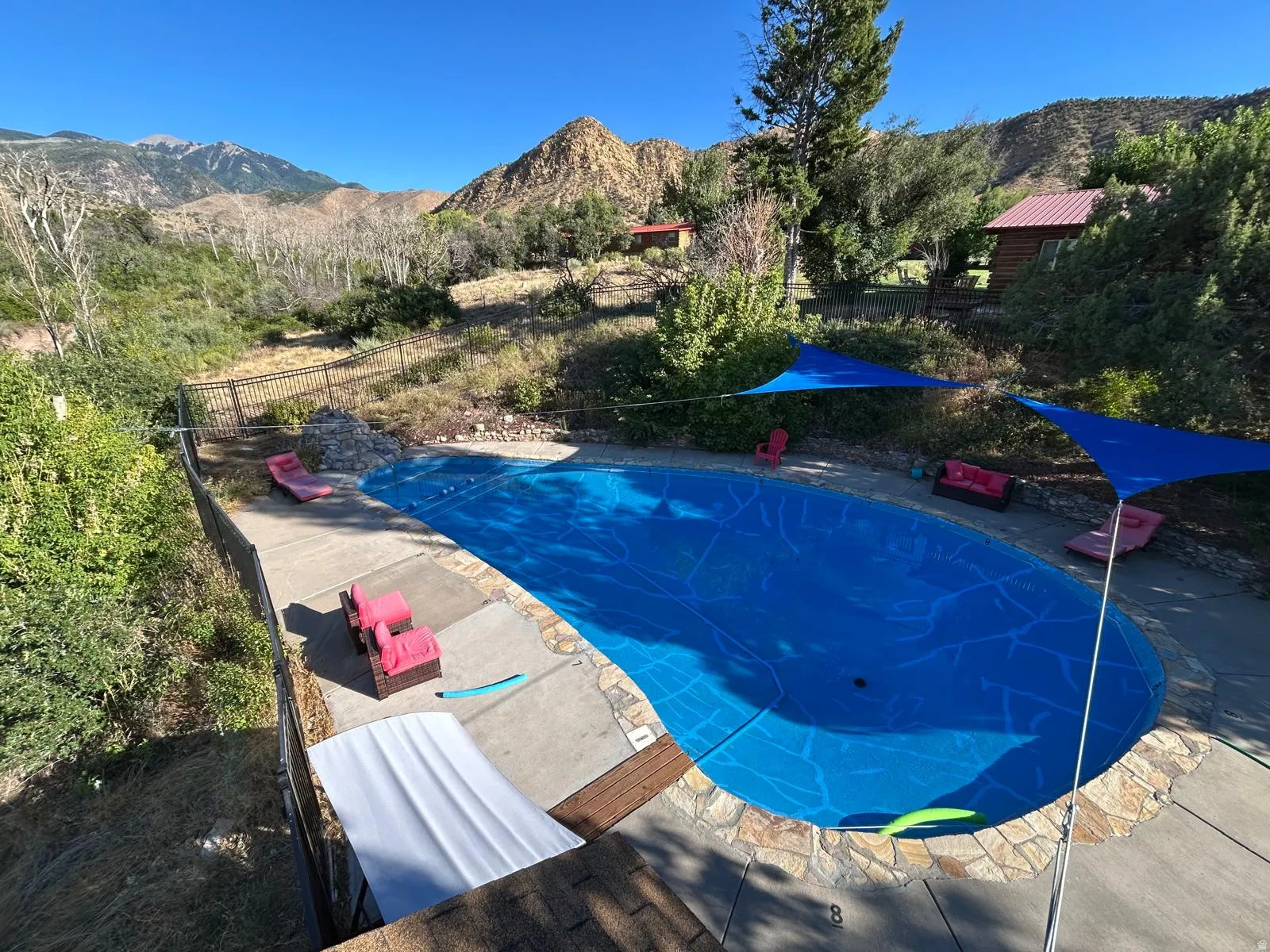 View of swimming pool featuring a mountain view, a fenced backyard, and patio surround