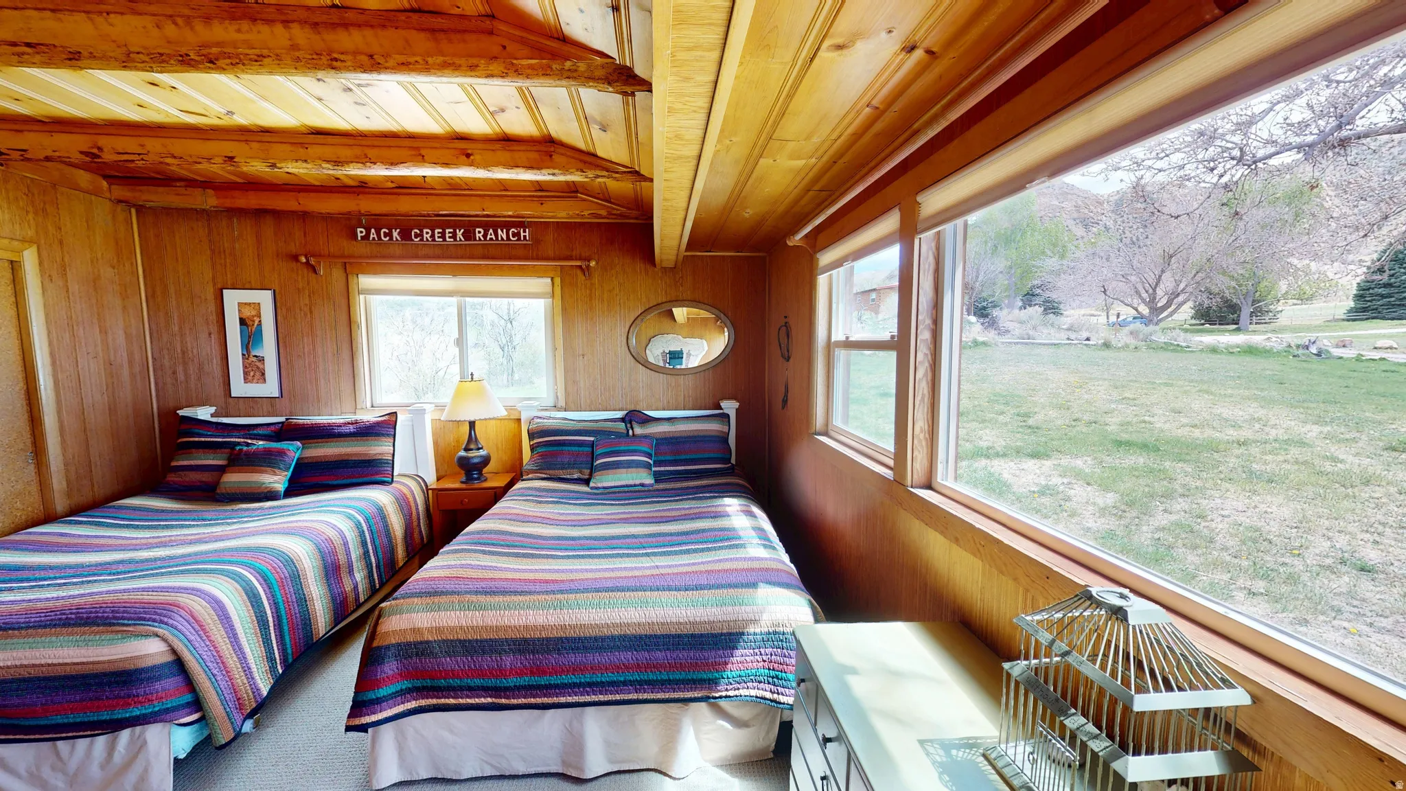 Bedroom featuring wooden walls and a wooden ceiling with exposed beams