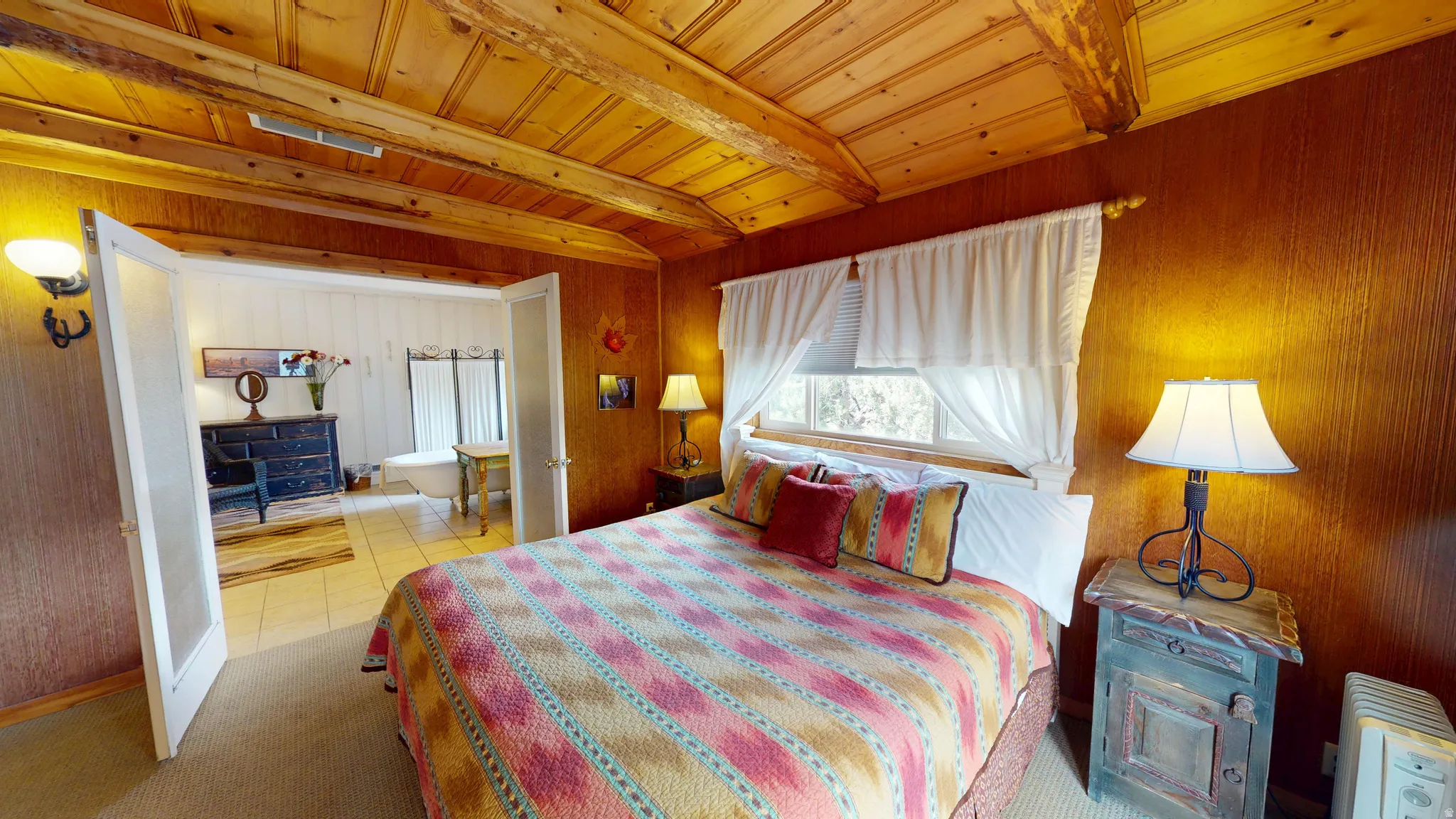 Bedroom featuring a wooden ceiling with exposed beams, light colored carpet, and wood walls