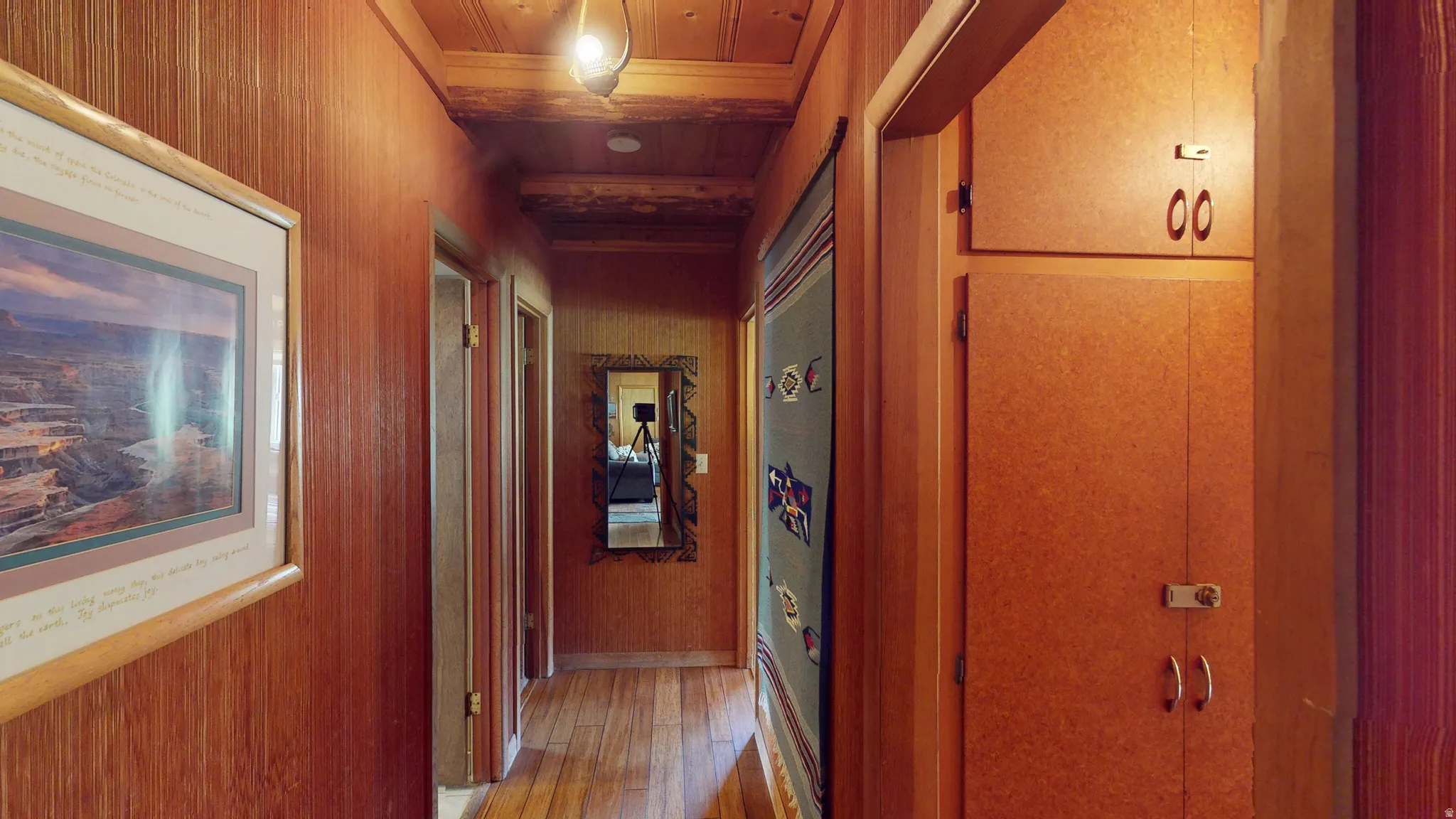 Hall with wood ceiling, wood walls, and light wood-type flooring