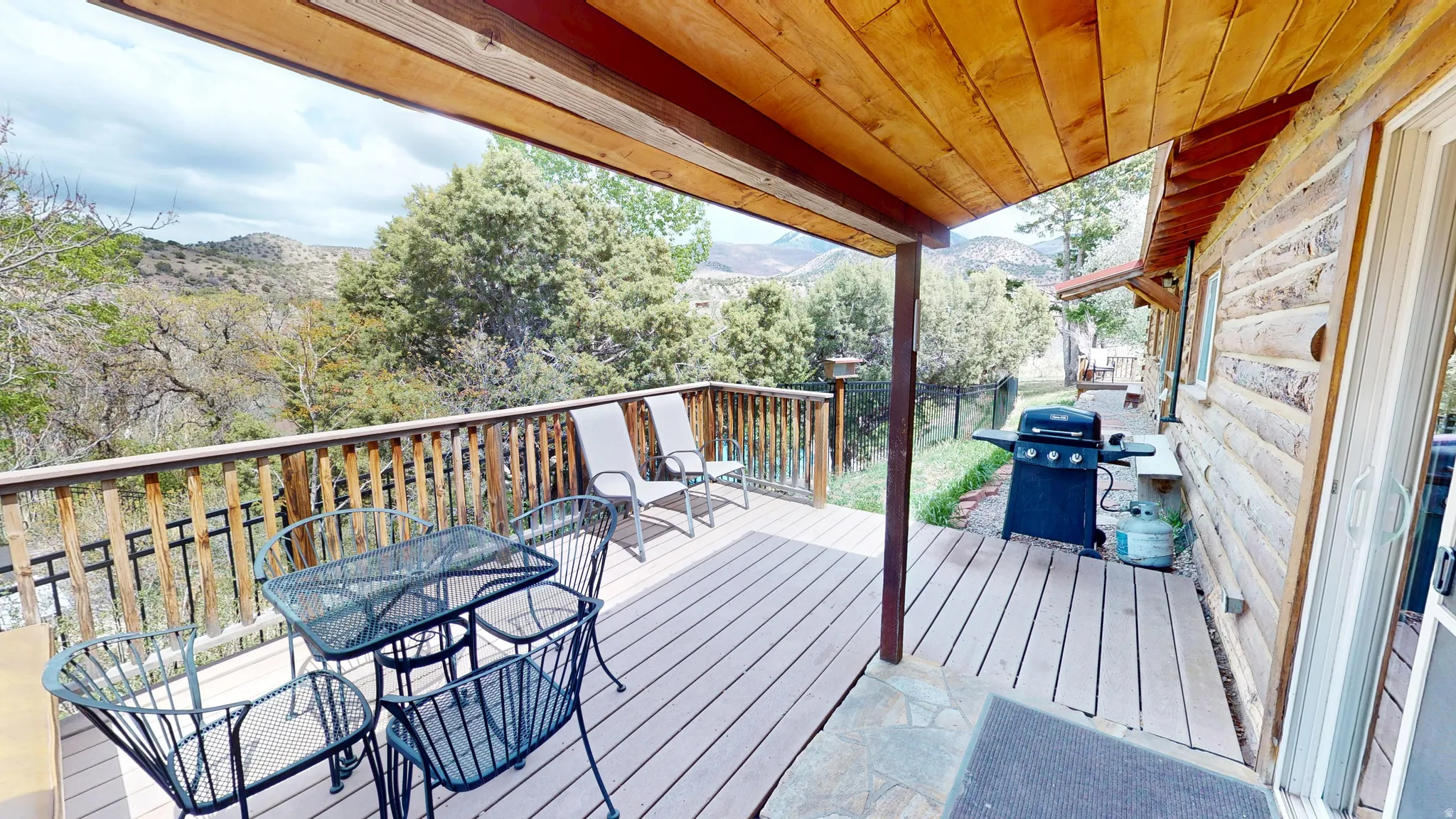 Deck featuring a grill, outdoor dining area, and a mountain view