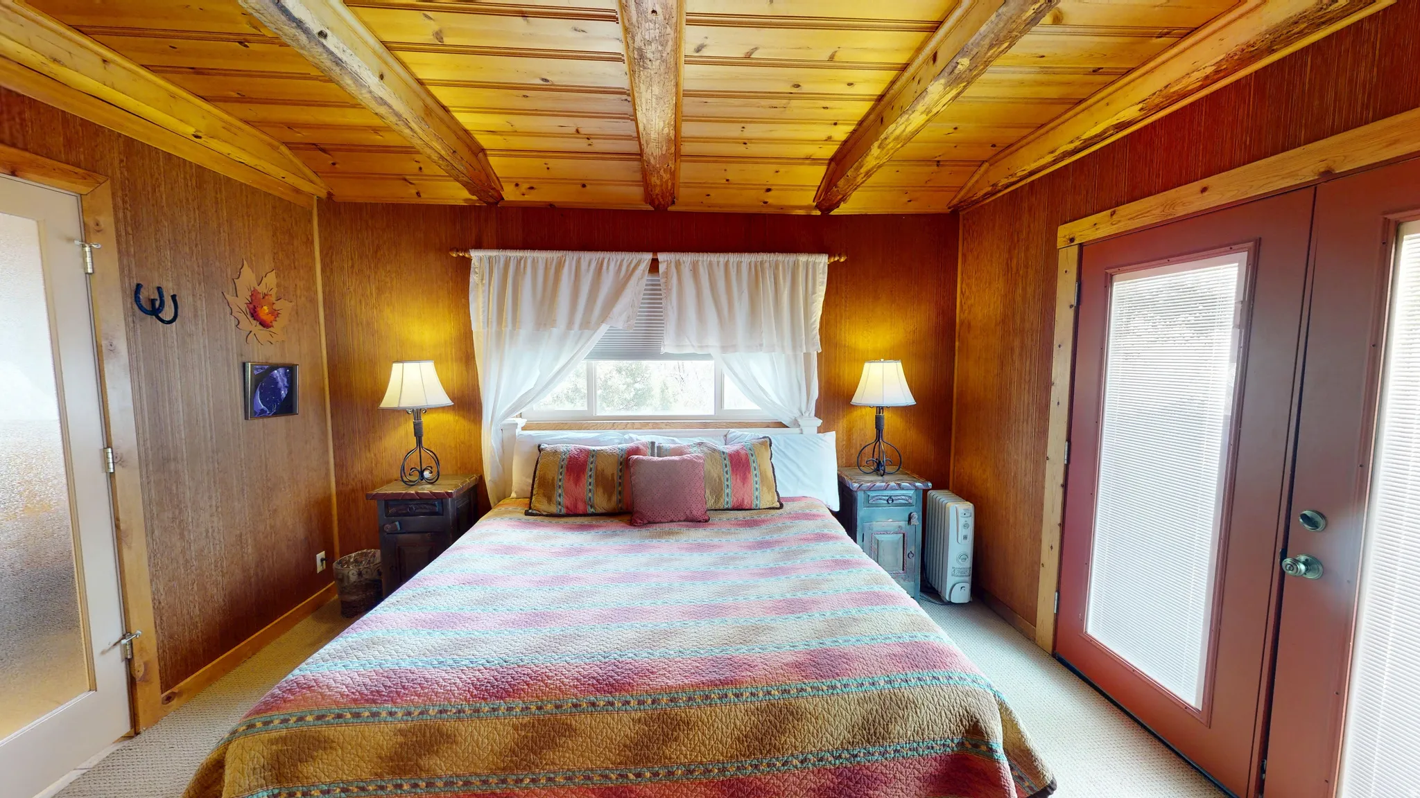 Bedroom featuring french doors, light colored carpet, wooden walls, and wood ceiling