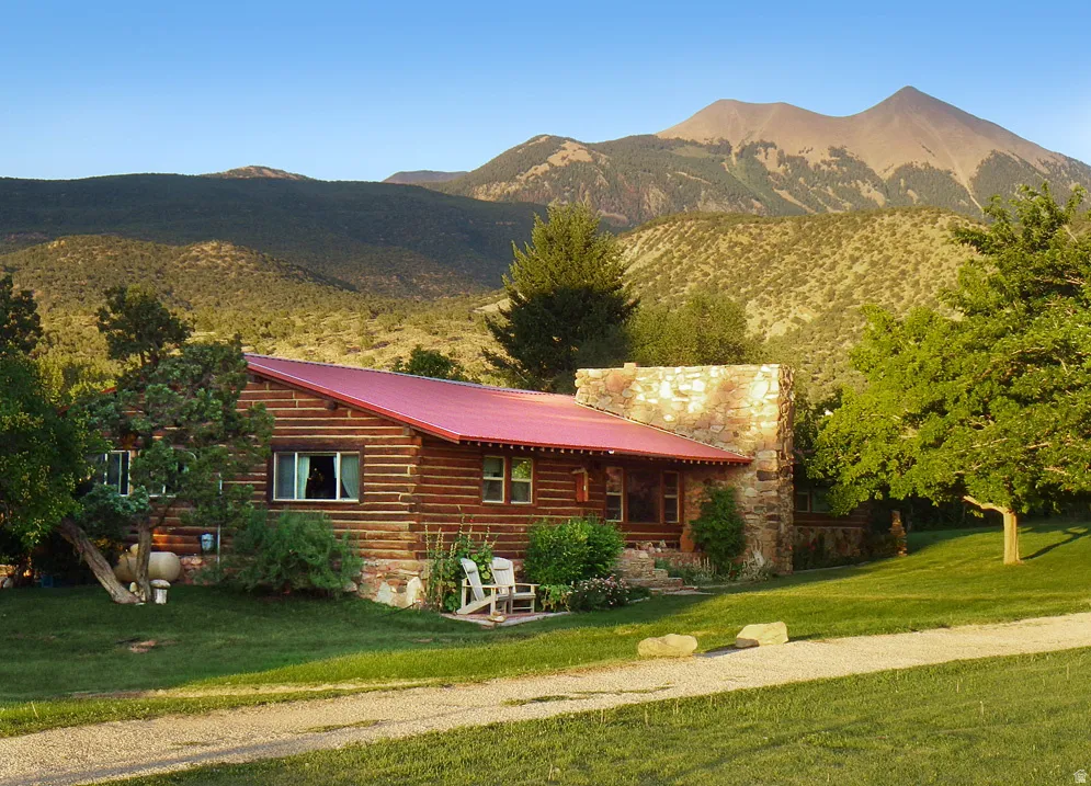 View of front of home featuring a mountain view, a front yard, a metal roof, and a porch