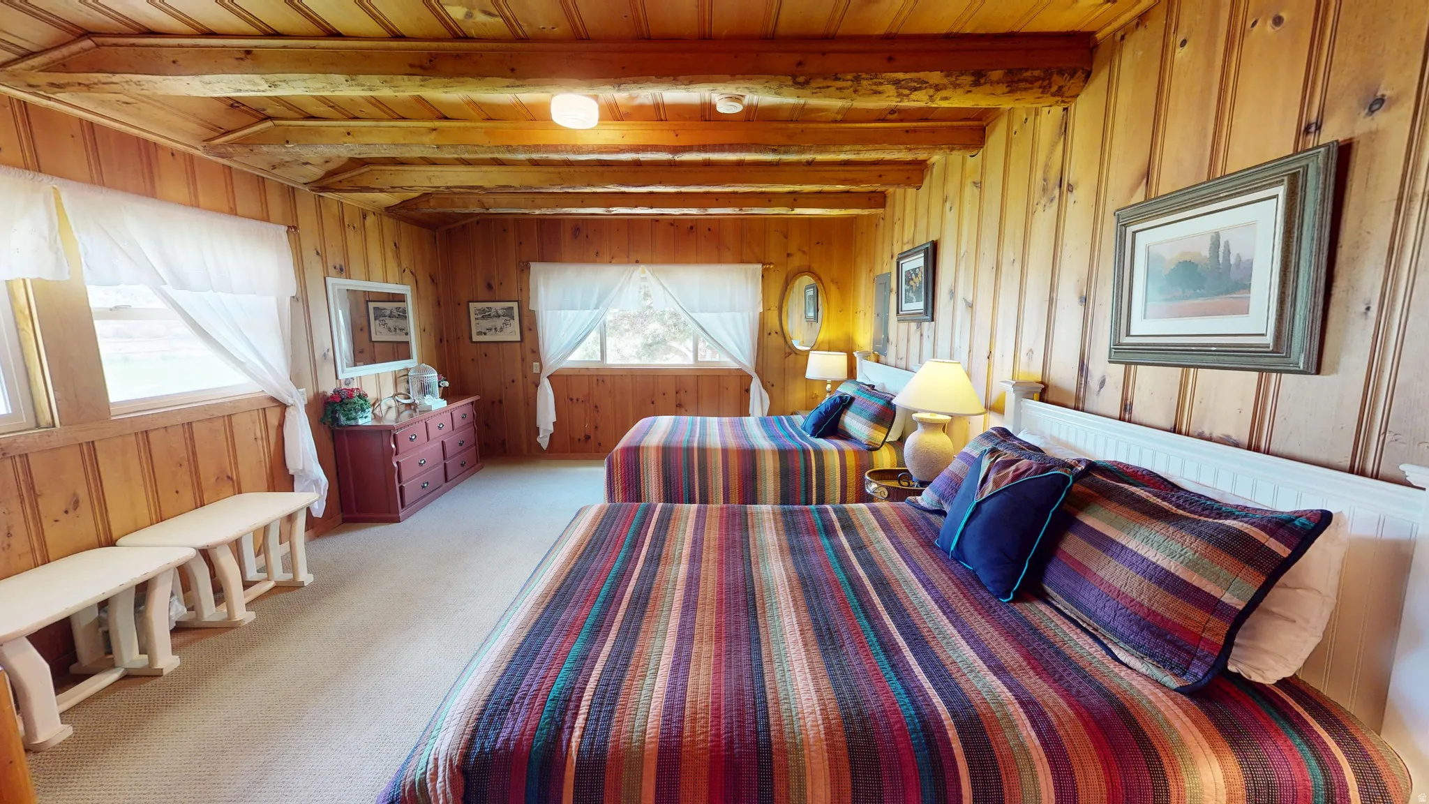 Bedroom featuring a wood ceiling with exposed beams, carpet, and wooden walls