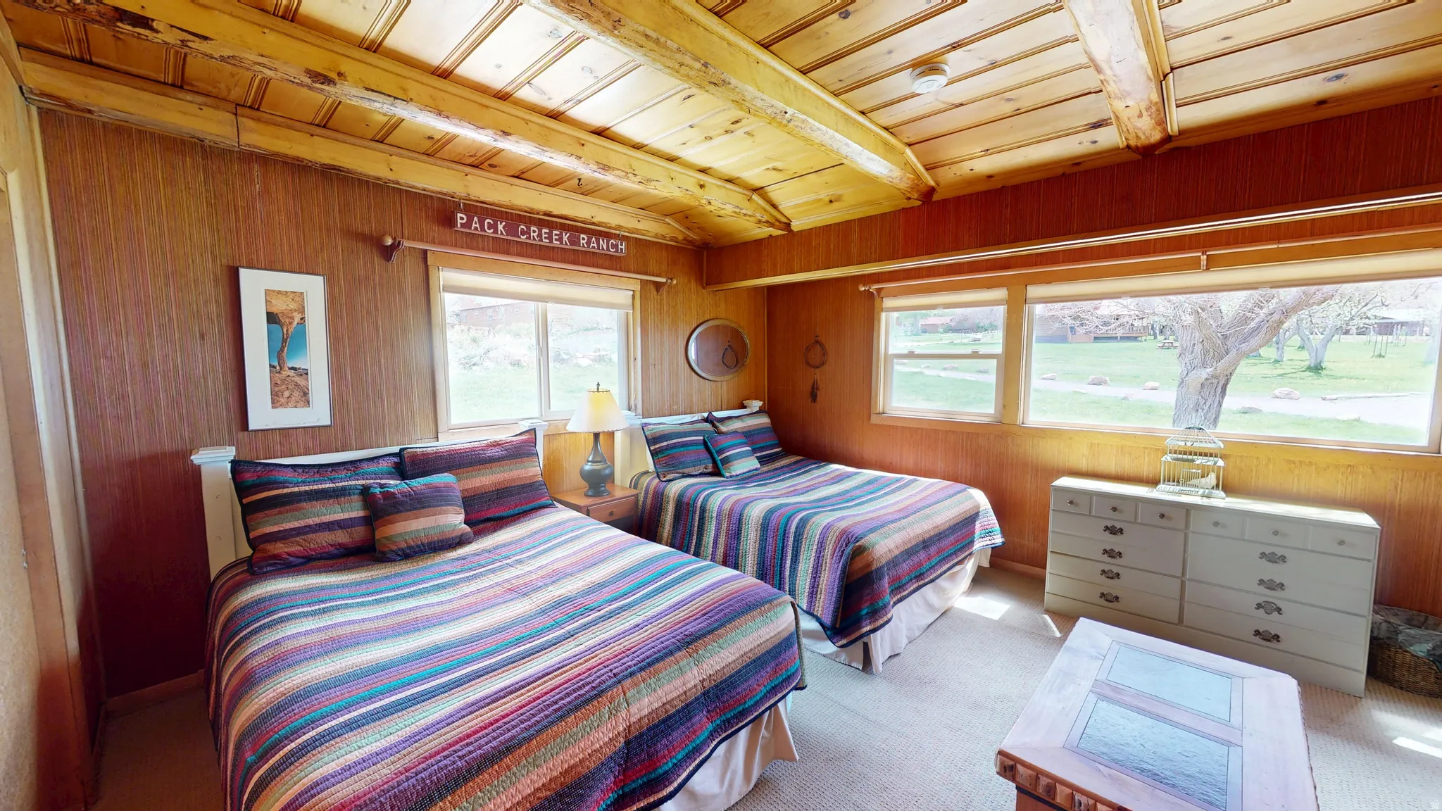 Bedroom featuring light carpet, wood walls, and a wood ceiling with exposed beams