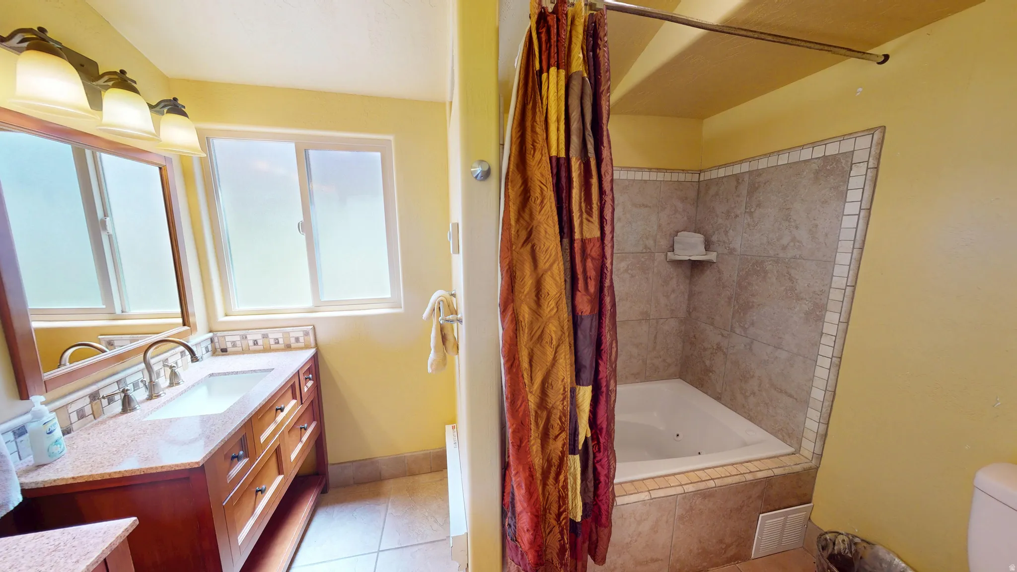 Full bathroom featuring vanity, tiled shower / bath, and light tile patterned flooring