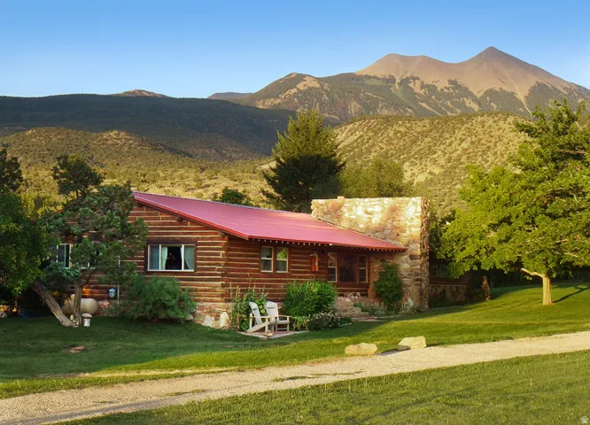 View of front of home featuring a mountain view, a front yard, a metal roof, and a porch