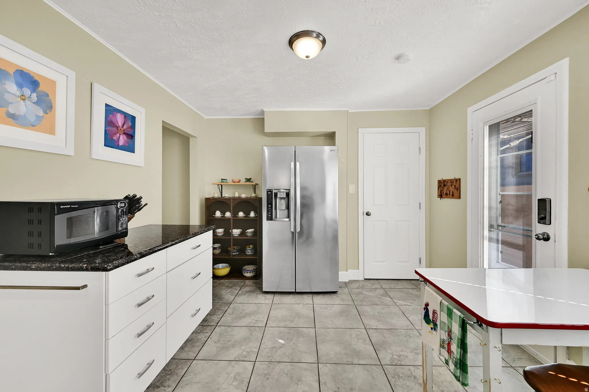 Kitchen featuring stainless steel appliances, updated white cabinetry, a large pantry, and granite counters.