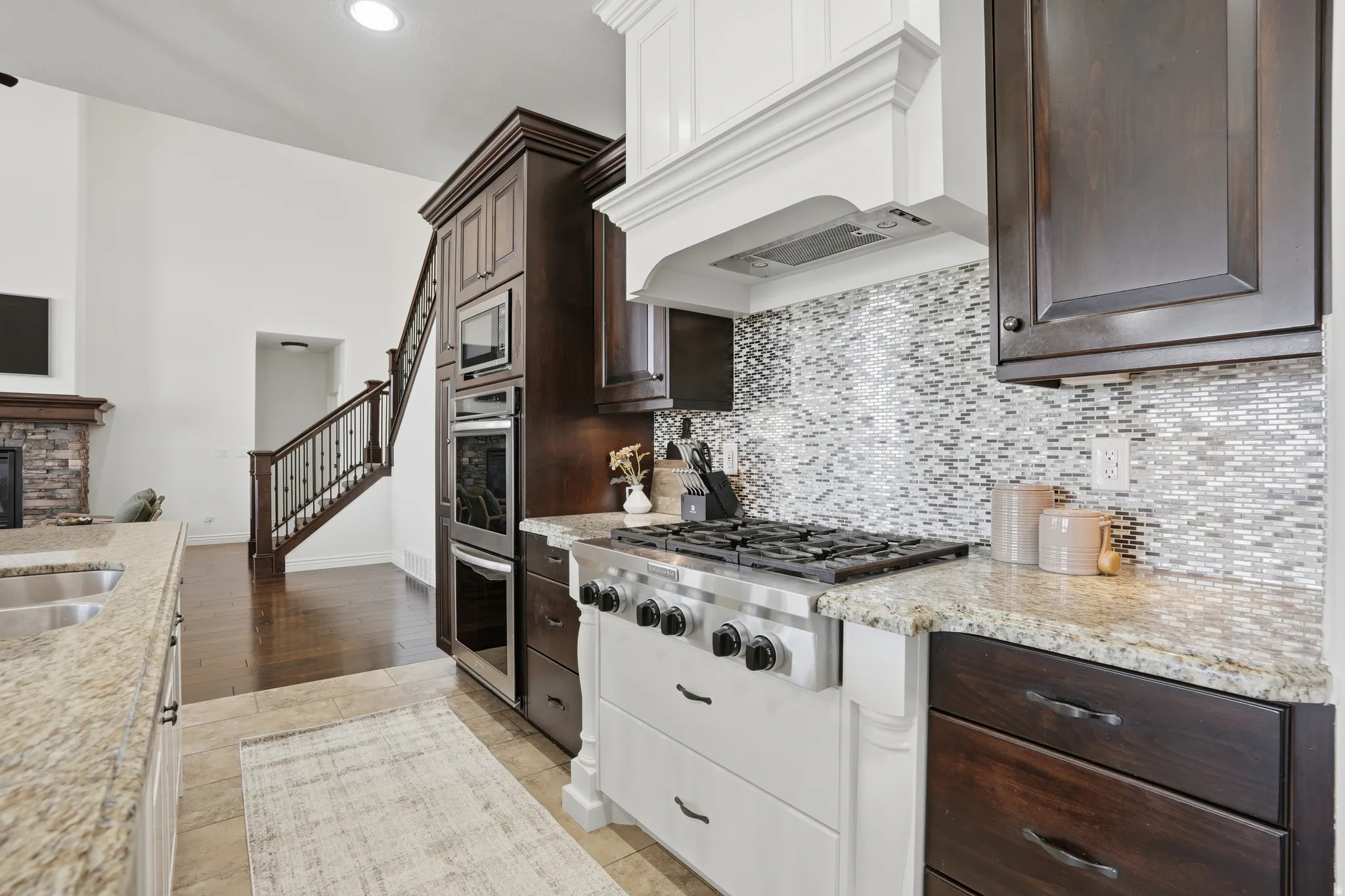 Kitchen with dark wood finish cabinetry, stainless steel appliances, and light stone countertops