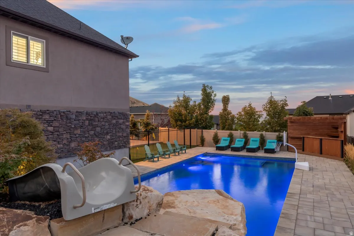View of swimming pool featuring a fenced backyard and patio surround
