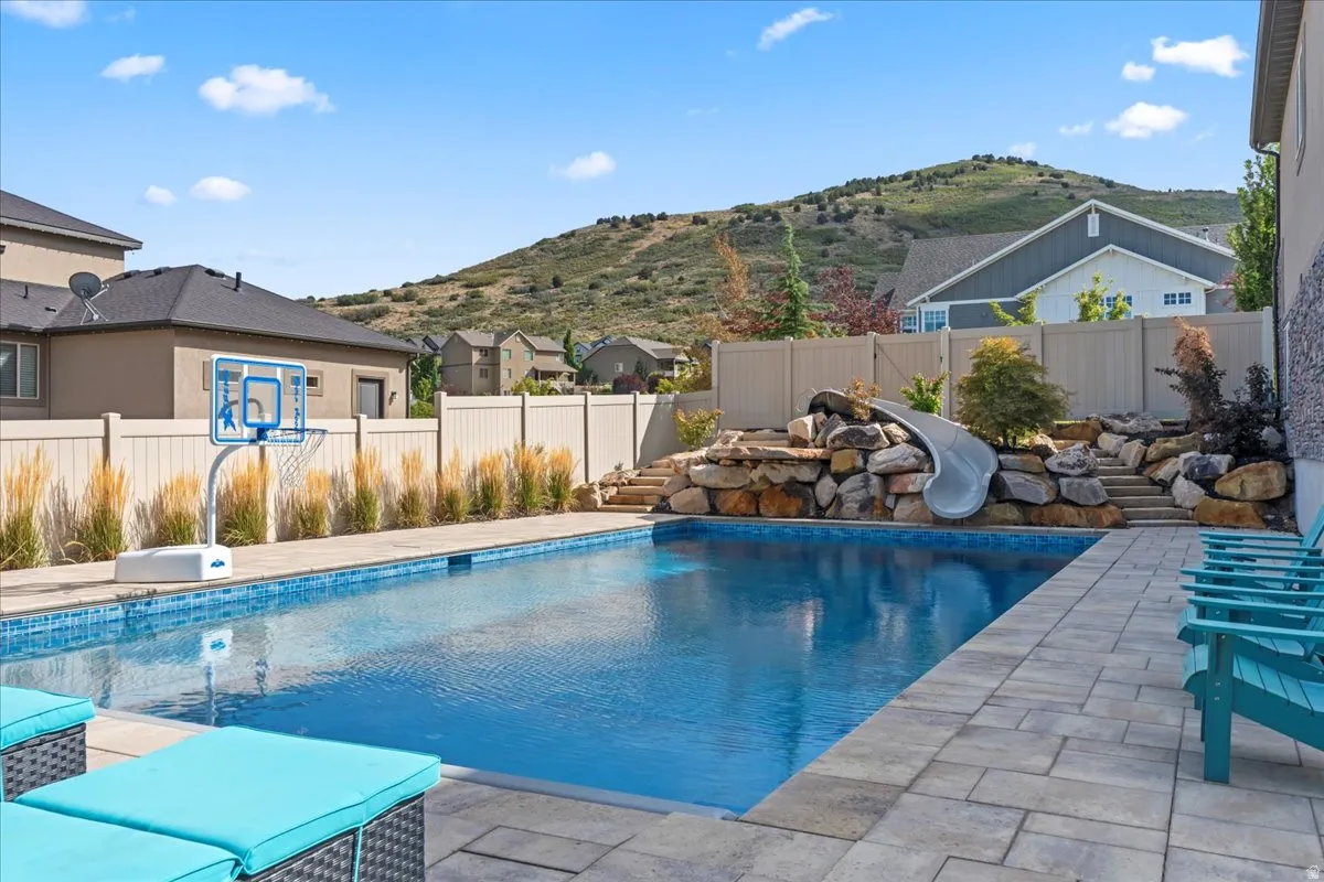 View of pool featuring patio surround, a fenced backyard, and a mountain view