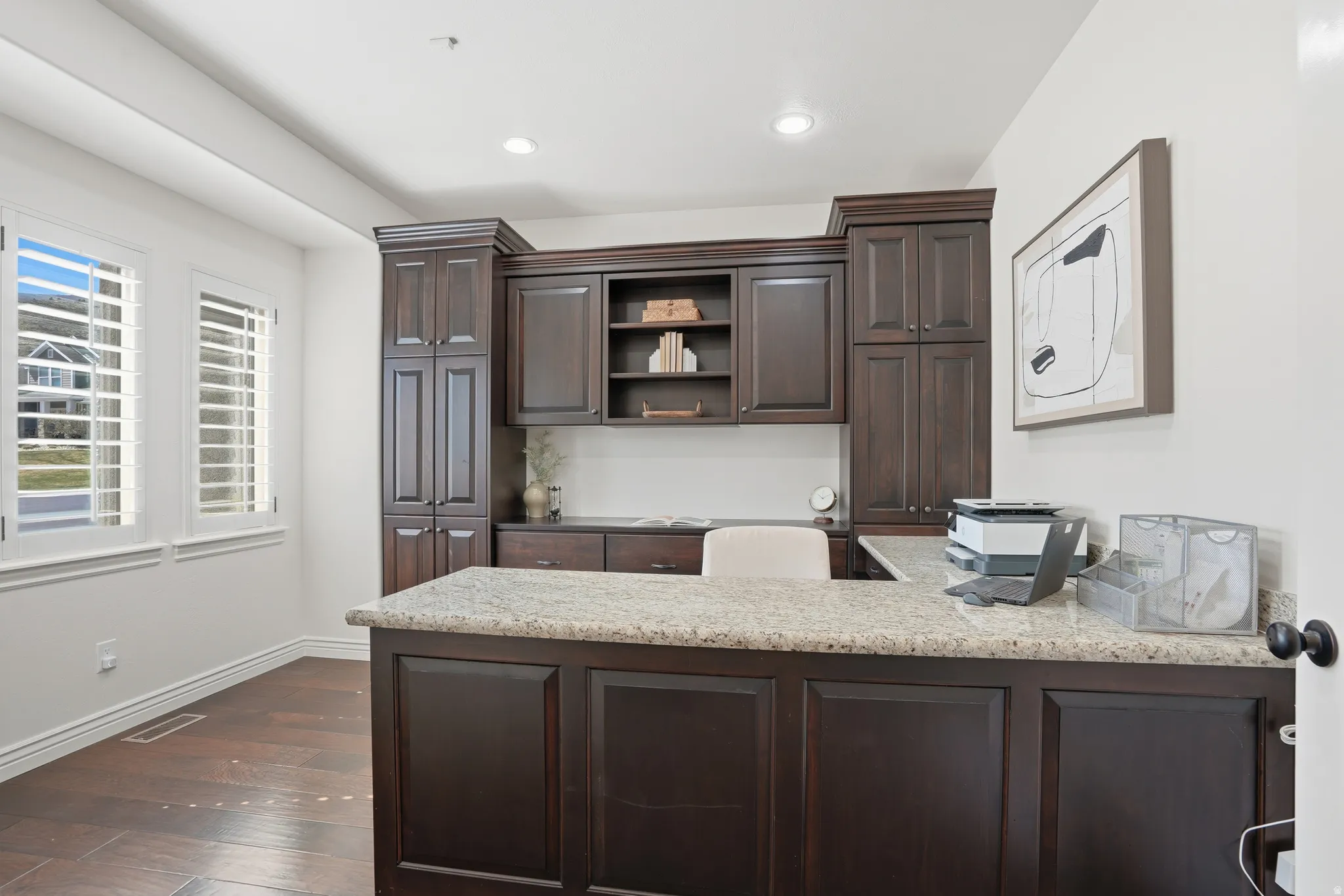 Kitchen with dark wood finish cabinetry, a peninsula, dark wood finished floors, light stone countertops, and open shelves
