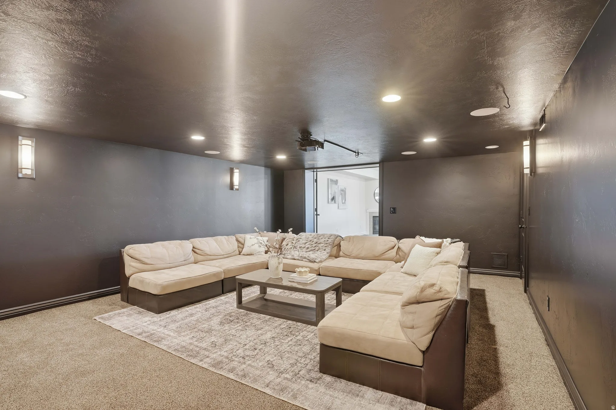 Living area featuring light carpet, a textured ceiling, and recessed lighting