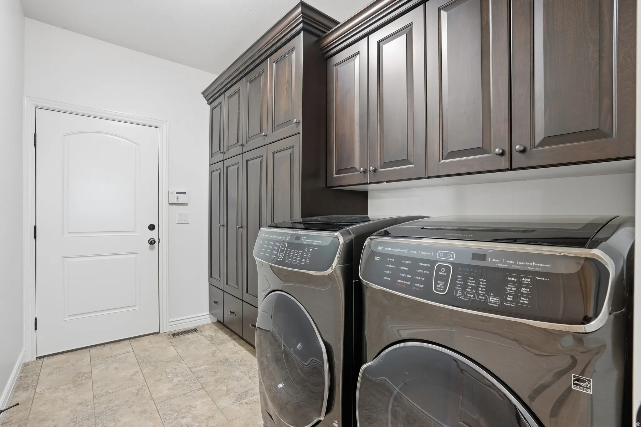 Laundry room featuring washer and clothes dryer and cabinet space