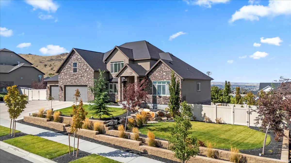 Craftsman-style home featuring stone siding, a gate, and concrete driveway