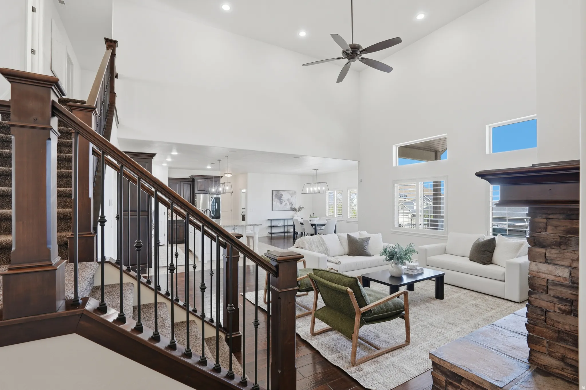 Living area featuring hardwood / wood-style floors, recessed lighting, a high ceiling, and ceiling fan