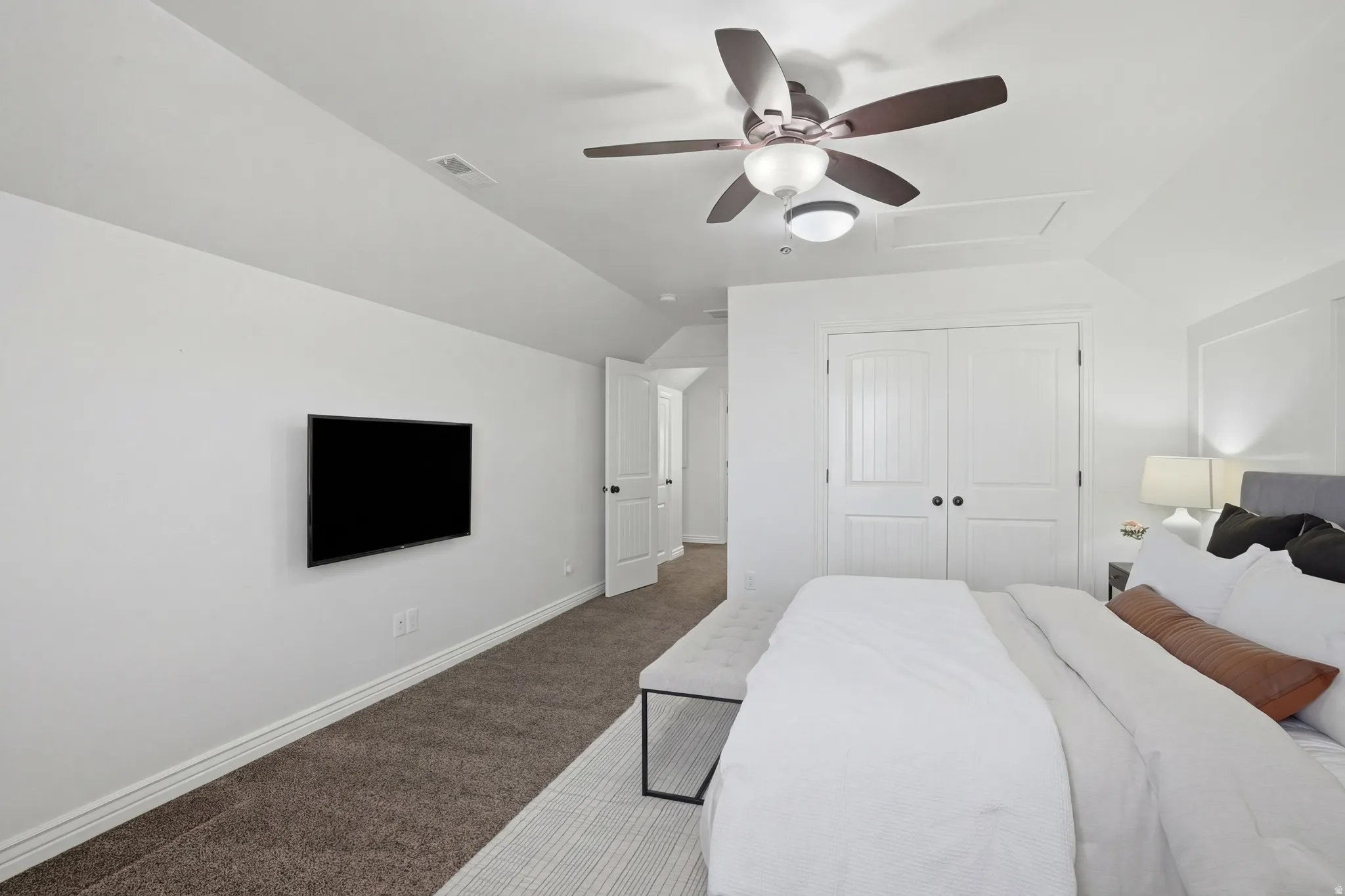 Bedroom featuring lofted ceiling, carpet, ceiling fan, and a closet
