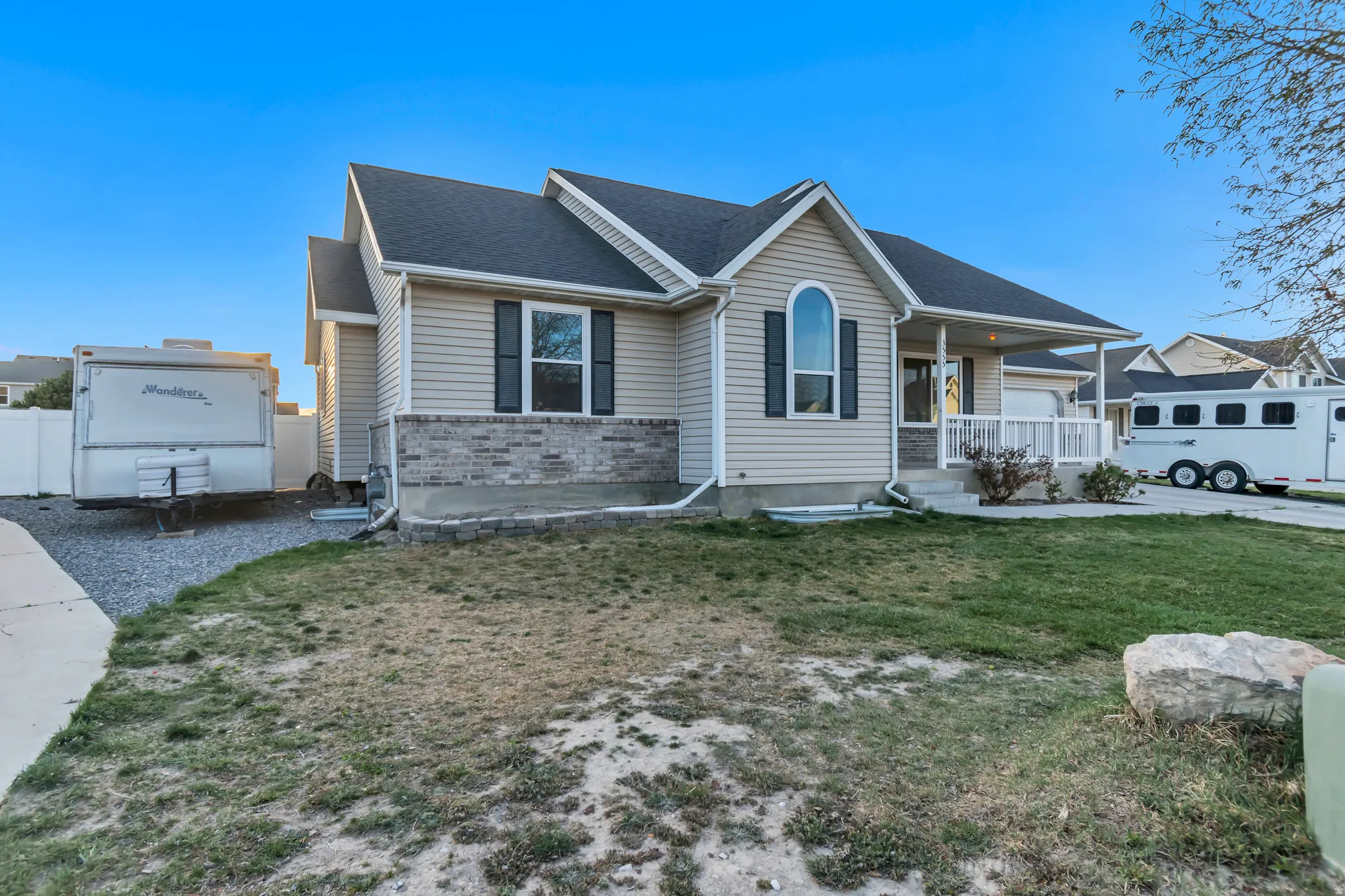 Ranch-style home with covered porch, a front yard, brick siding, and roof with shingles