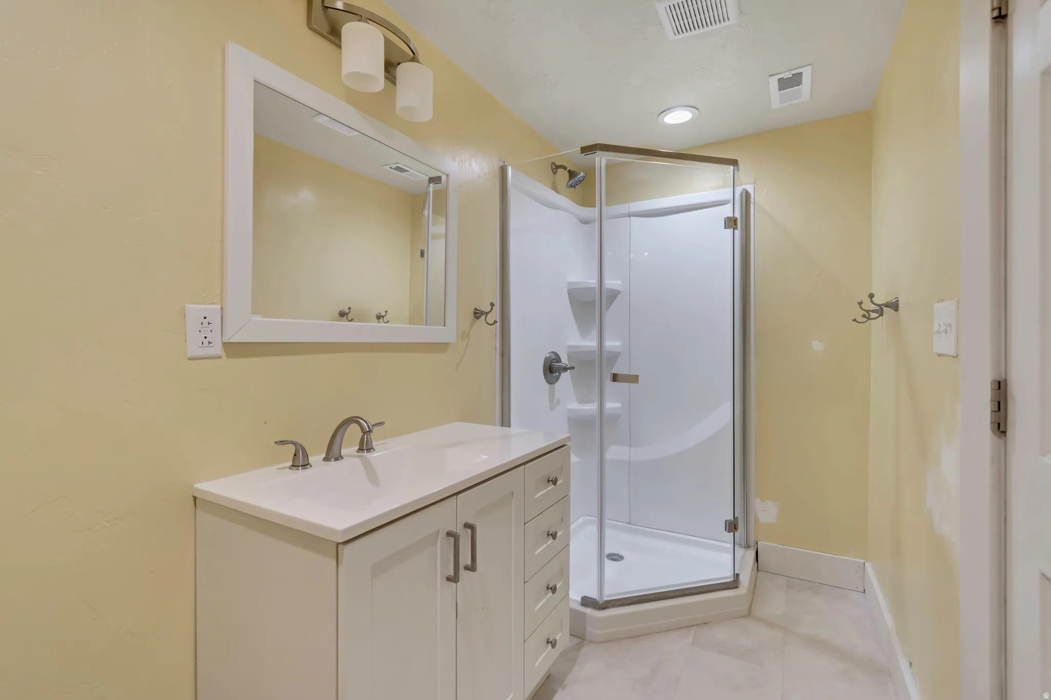 Full bathroom with vanity, a shower stall, and light tile patterned flooring