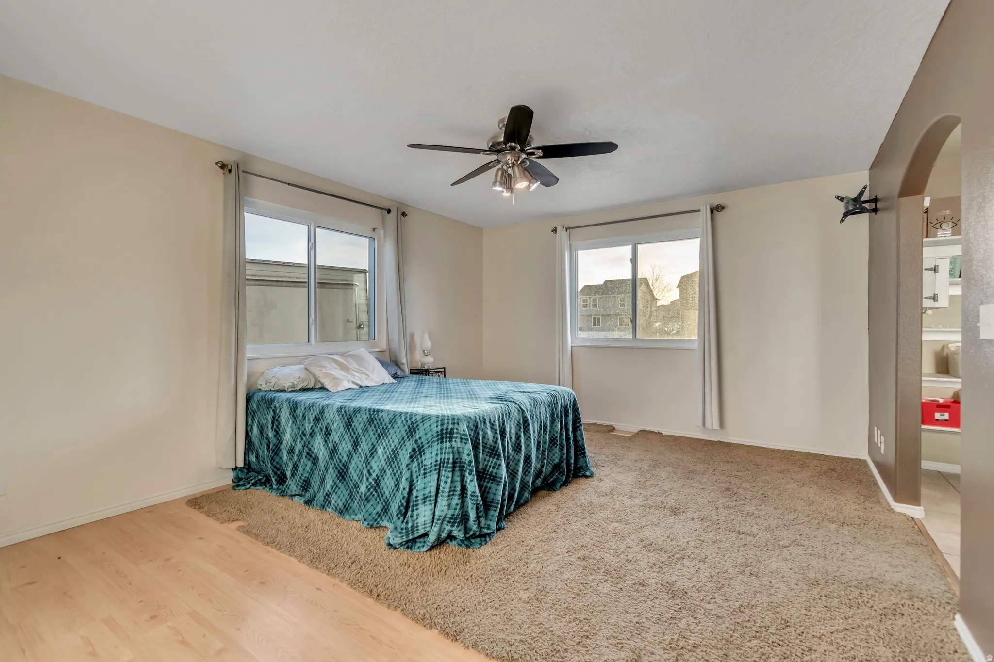 Bedroom with arched walkways and ceiling fan