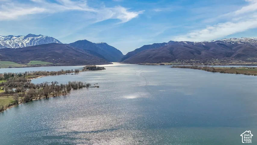 Expansive waterfront setting with surrounding mountains and a clear blue sky overhead