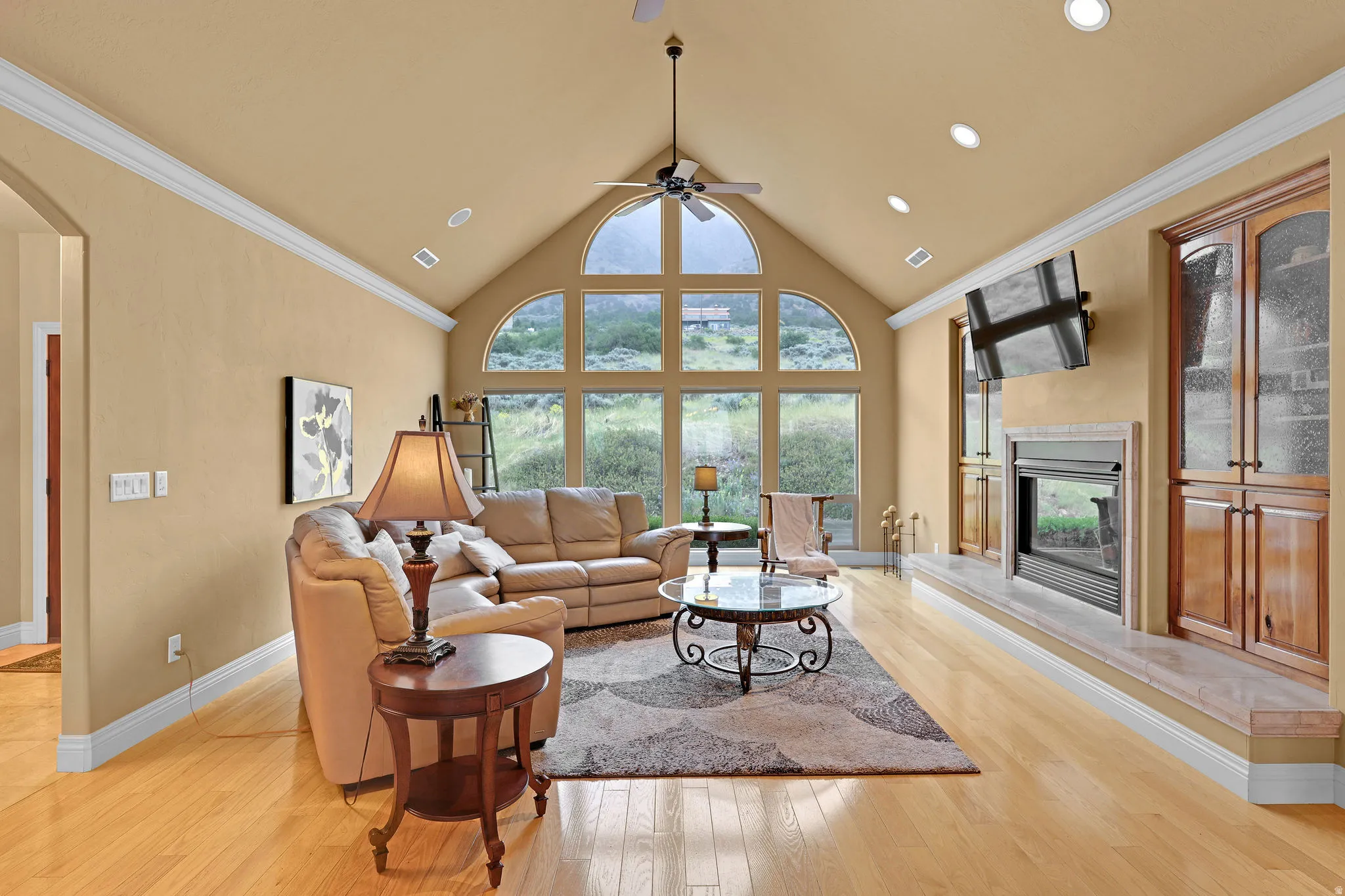 Spacious living area featuring a vaulted ceiling and expansive arched windows