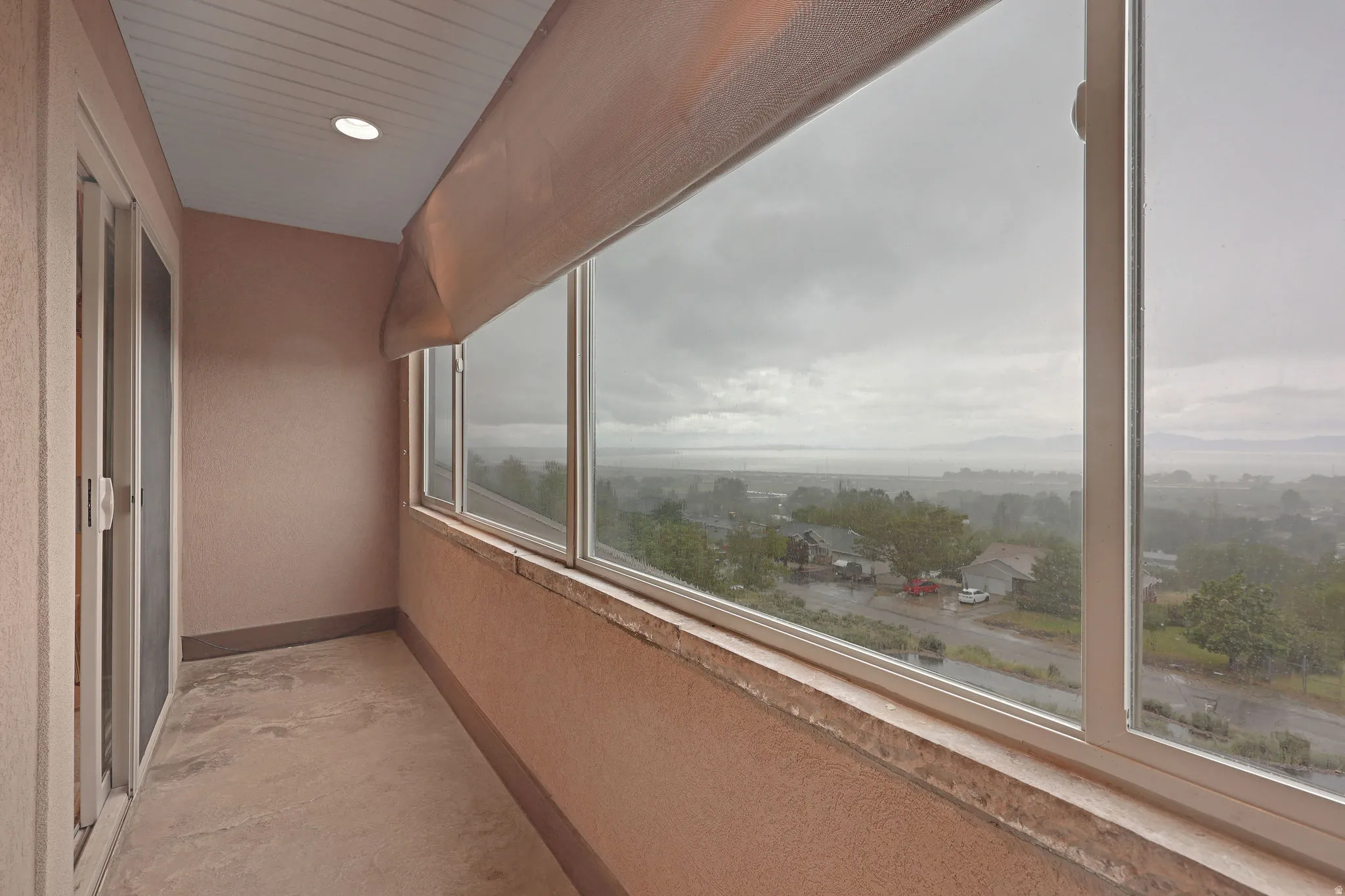 Enclosed balcony with expansive windows offering panoramic scenery