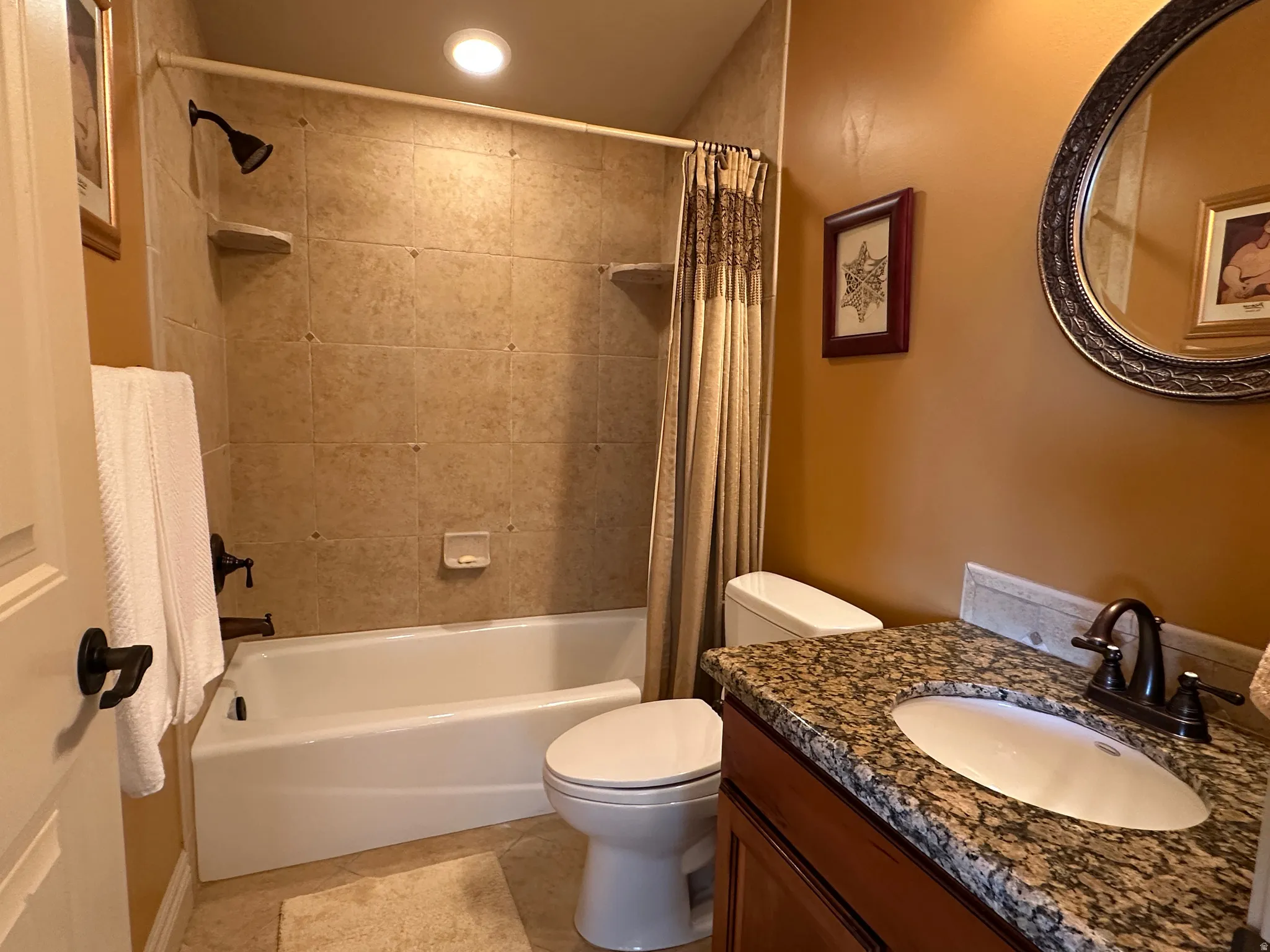Full bathroom with garnite vanity and shower / tub combo