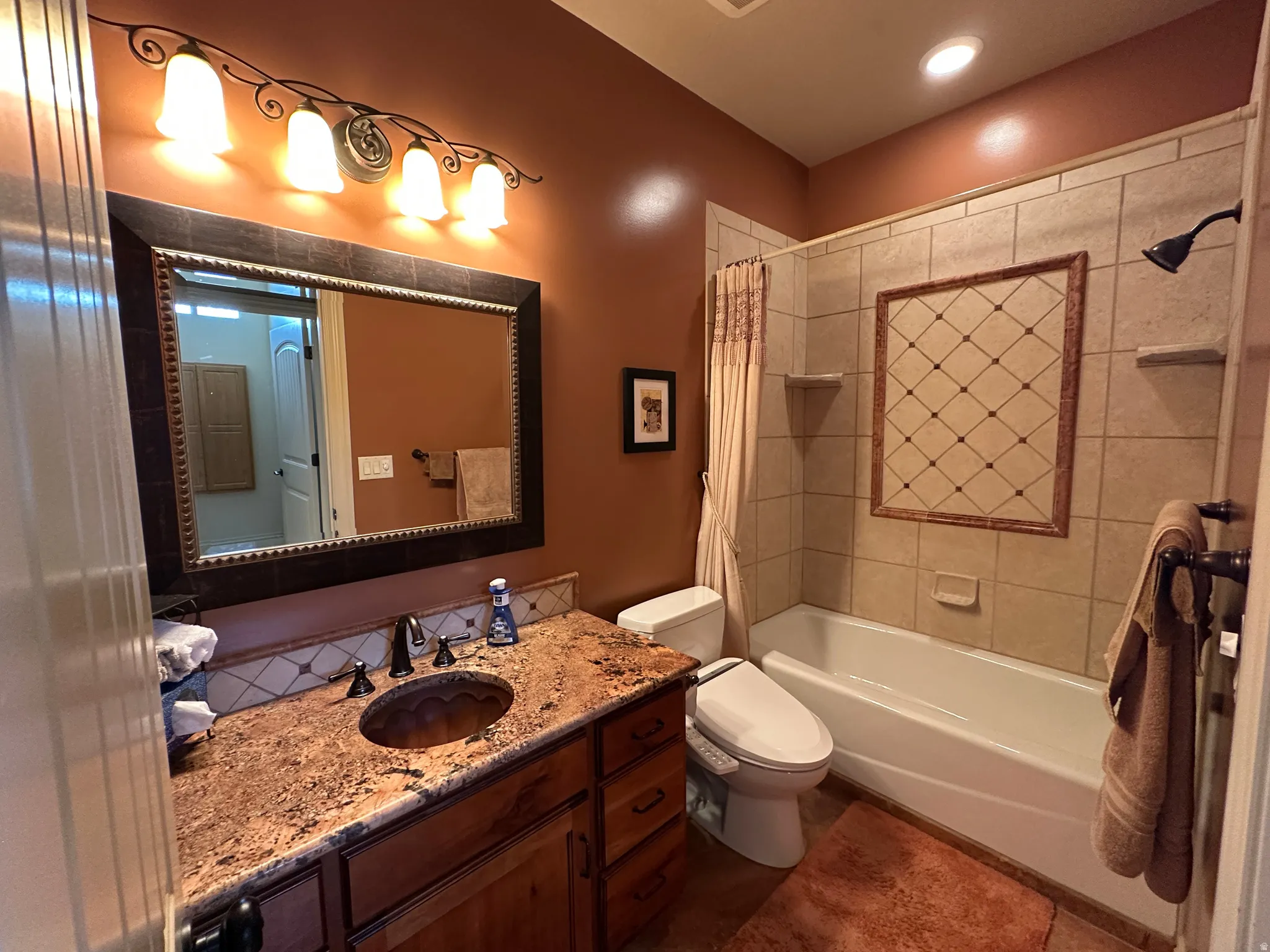 Bathroom featuring vanity and shower / bath combination with decorative tile