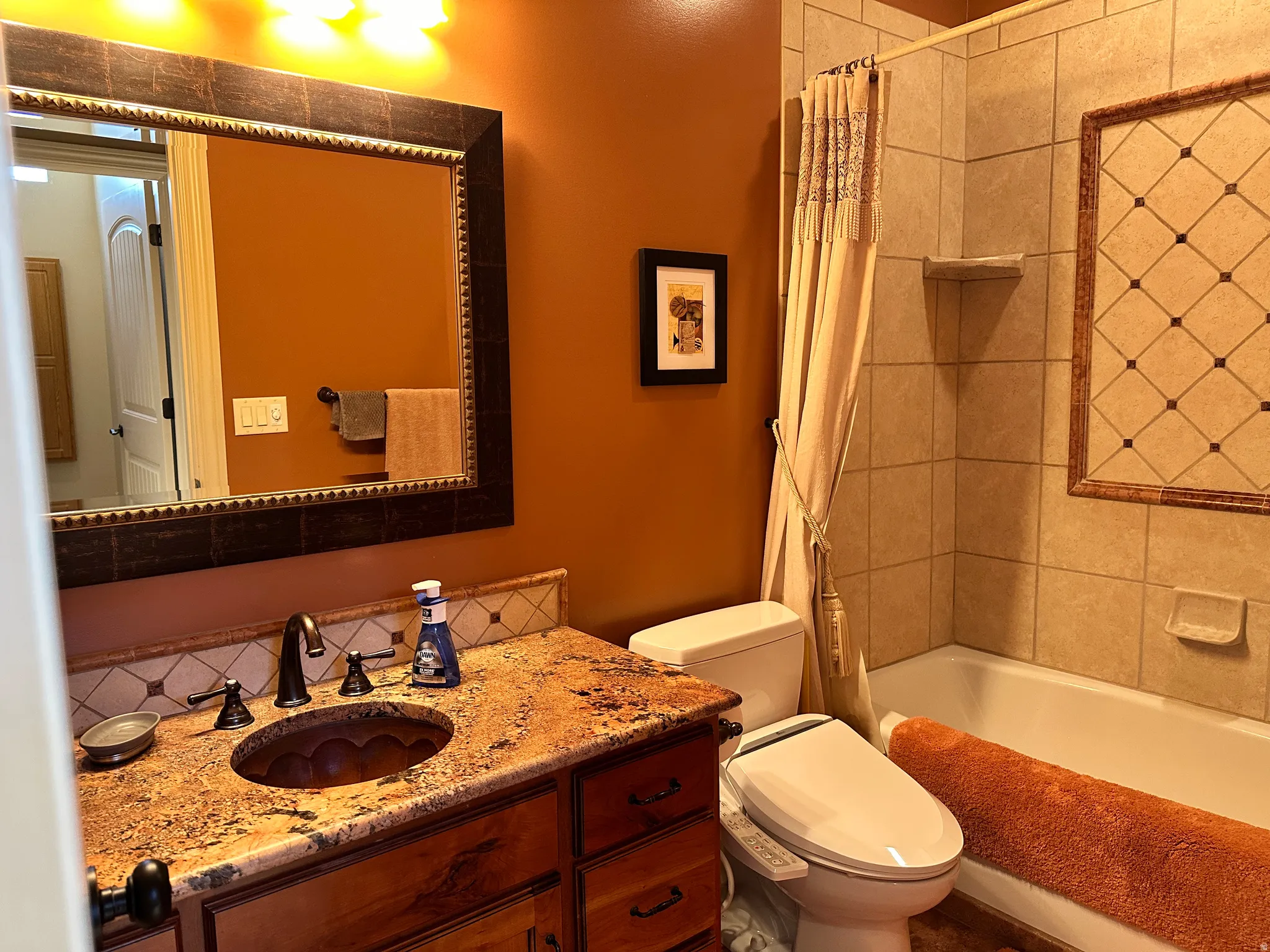 Decorative tile tub surrond and granite counter with copper sink