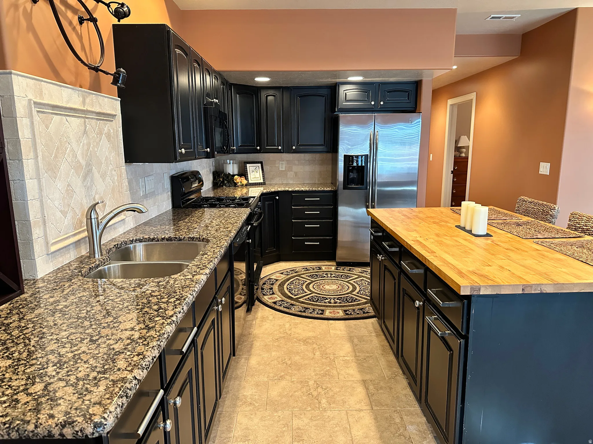Granite counters, tile back splash and black appliances