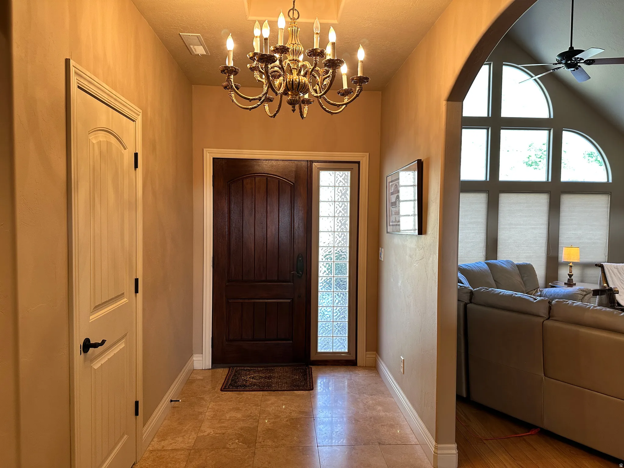 Foyer entrance featuring ceiling fan and suspended lighting