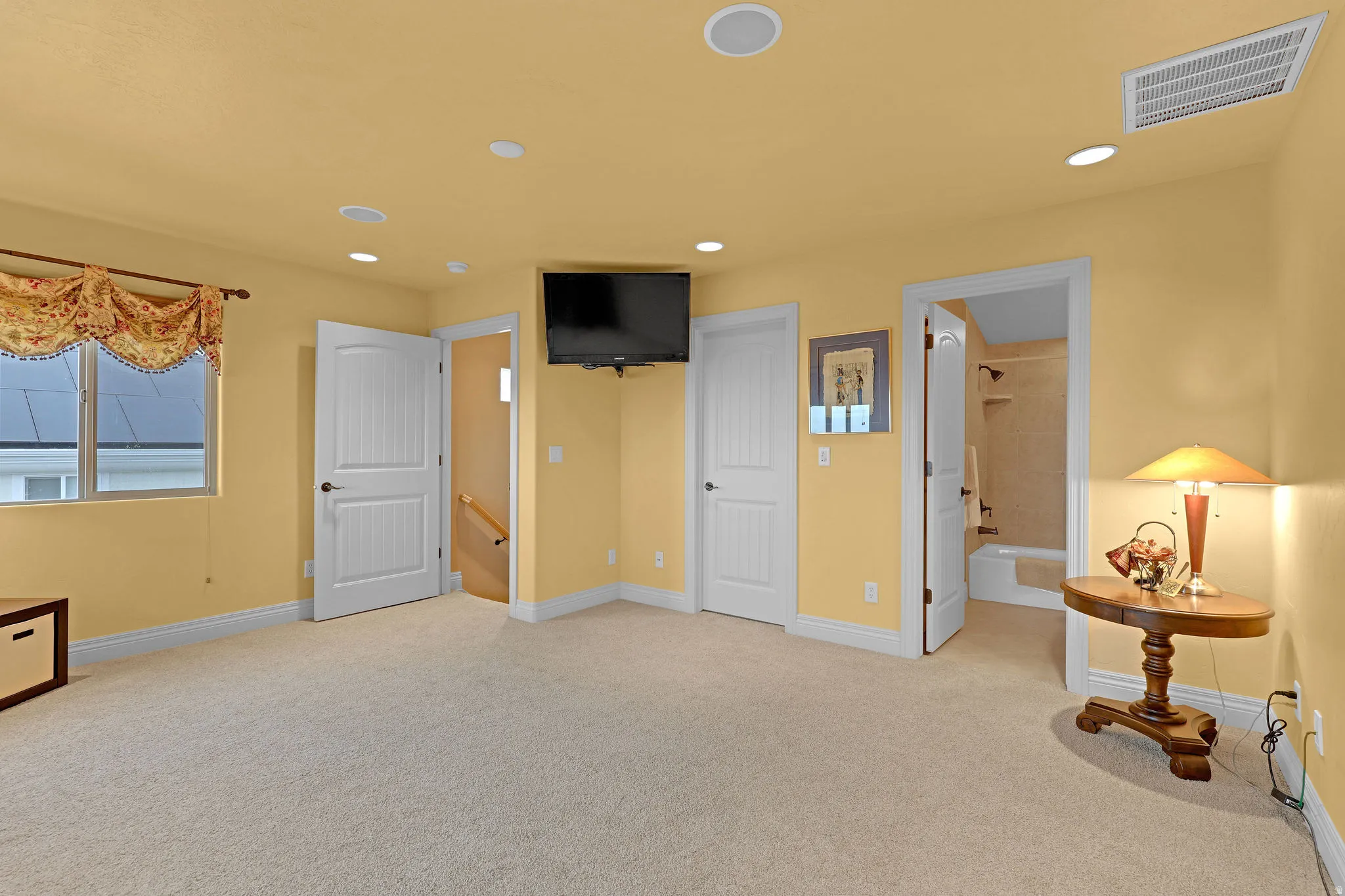 Carpeted interior space with recessed lighting and a ceiling-mounted vent