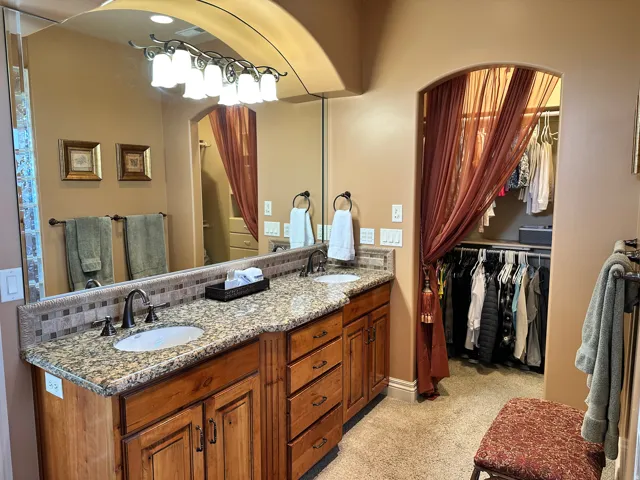 Primary bath with double vanity and a walk in closet