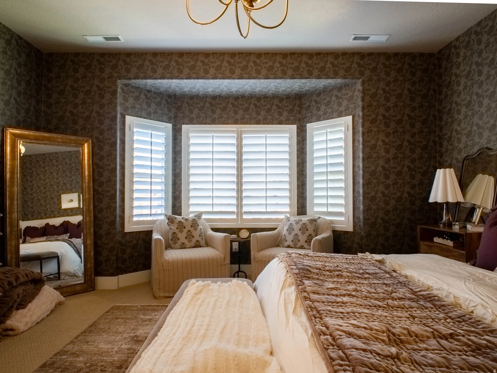 Carpeted bedroom with wallpapered walls and suspended lighting