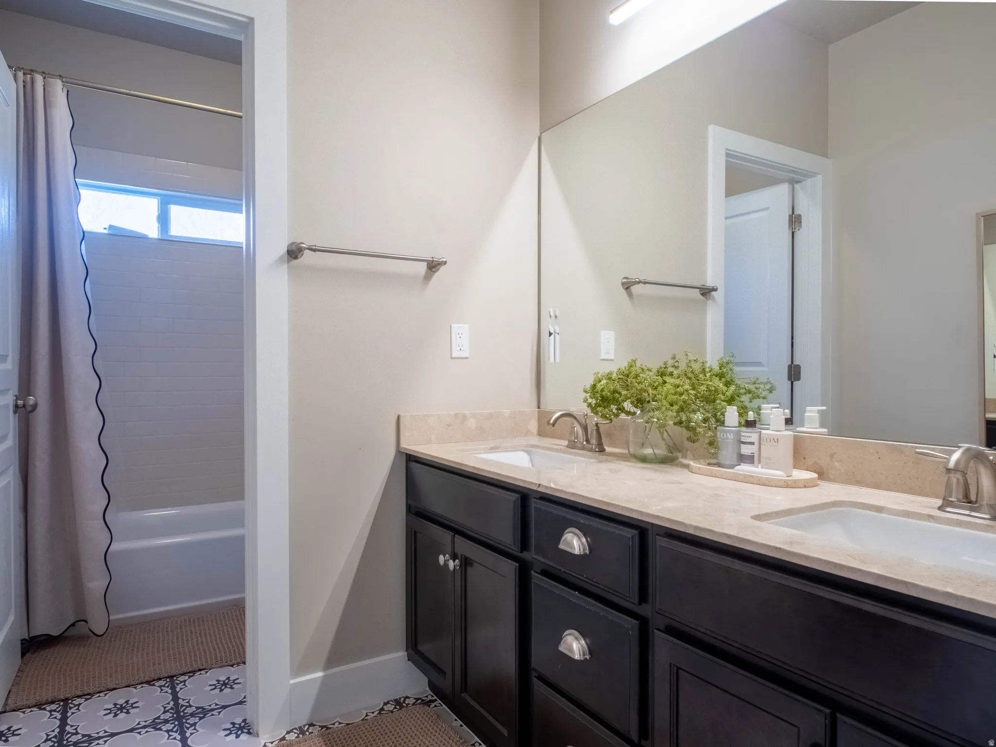 Full bathroom with double vanity and shower / bathtub combination with curtain