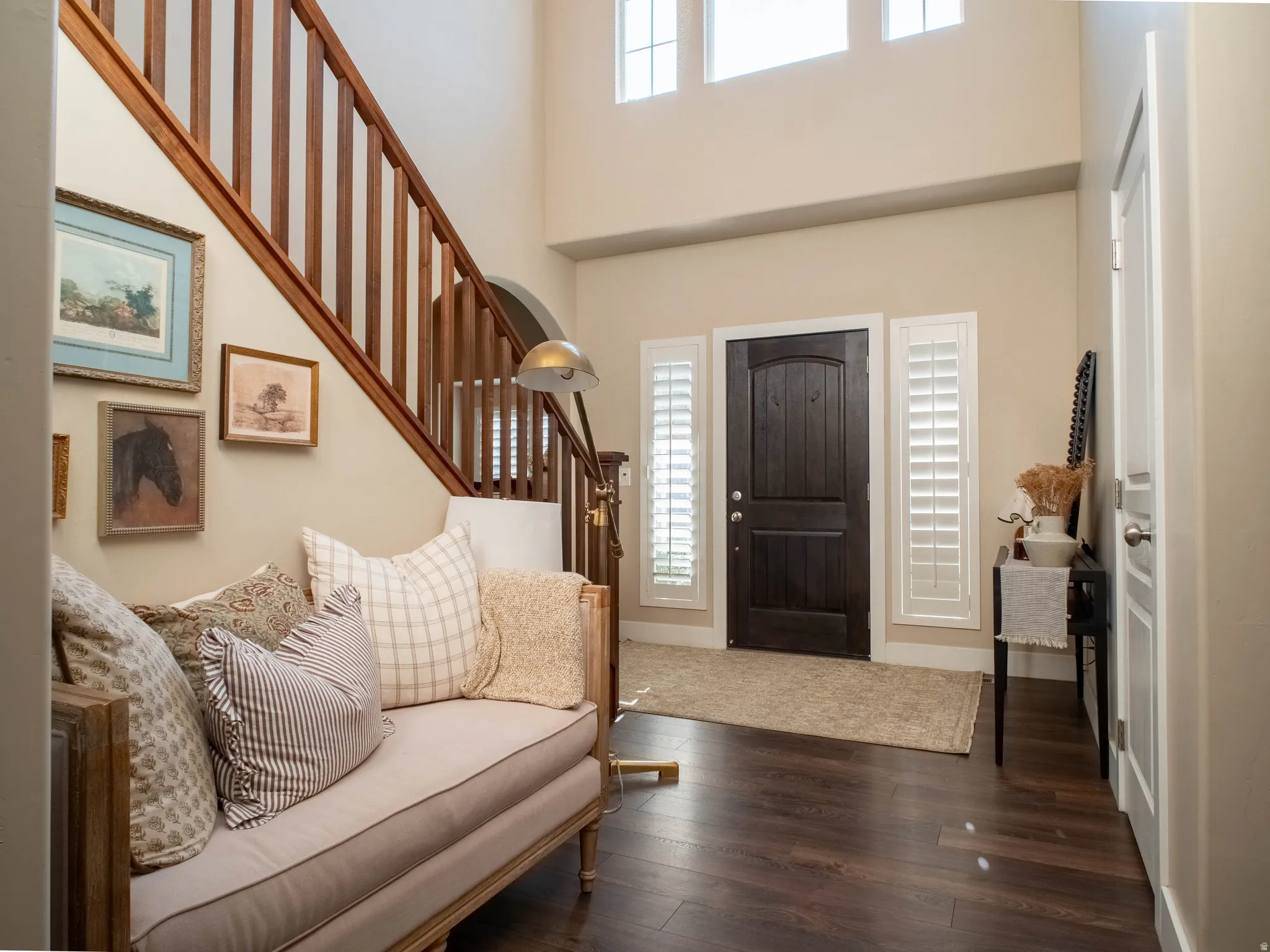 Foyer with dark wood finished floors and a high ceiling