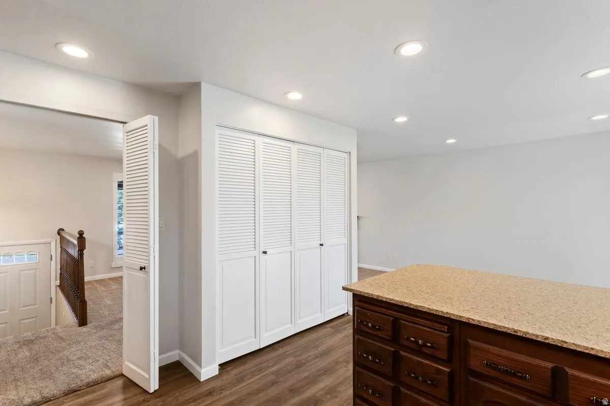 Kitchen with light stone counters, dark wood finished floors, recessed lighting, and dark wood finish cabinets