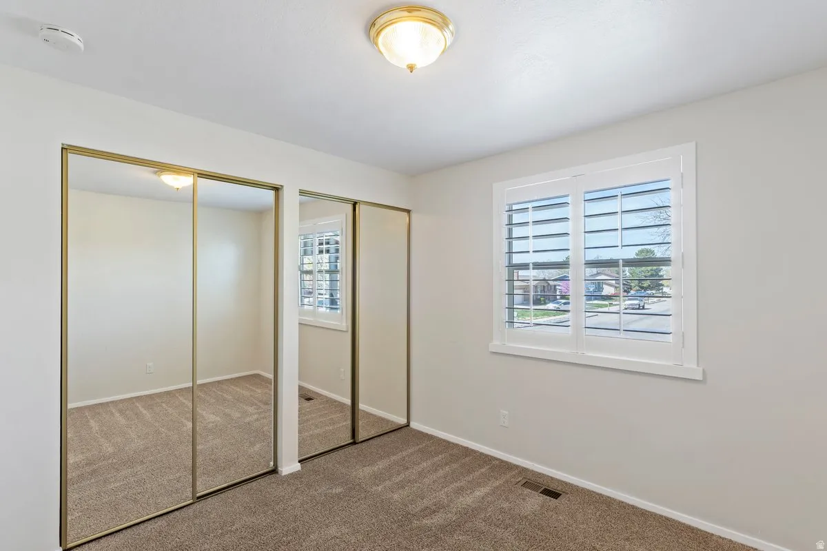 Unfurnished bedroom with two closets and carpet flooring
