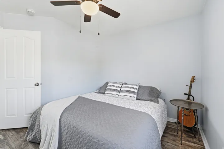 Bedroom featuring ceiling fan and dark wood-type flooring